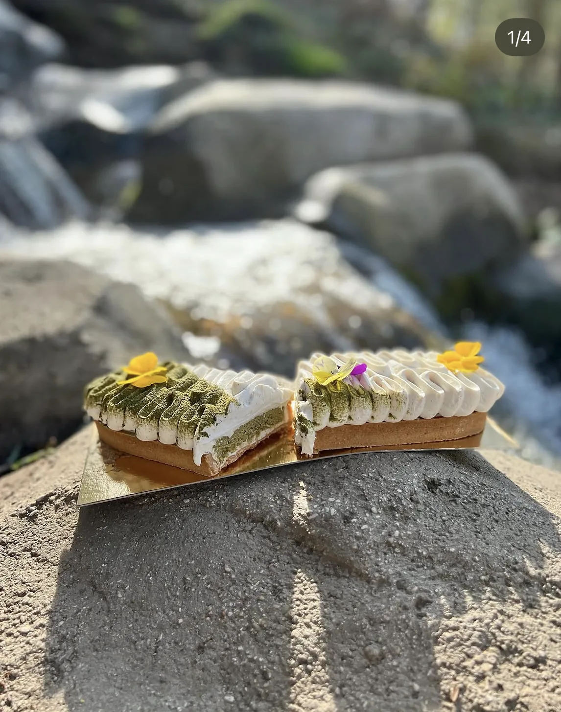 Un éclair à la pistache posé sur un rocher, au bord de l'eau