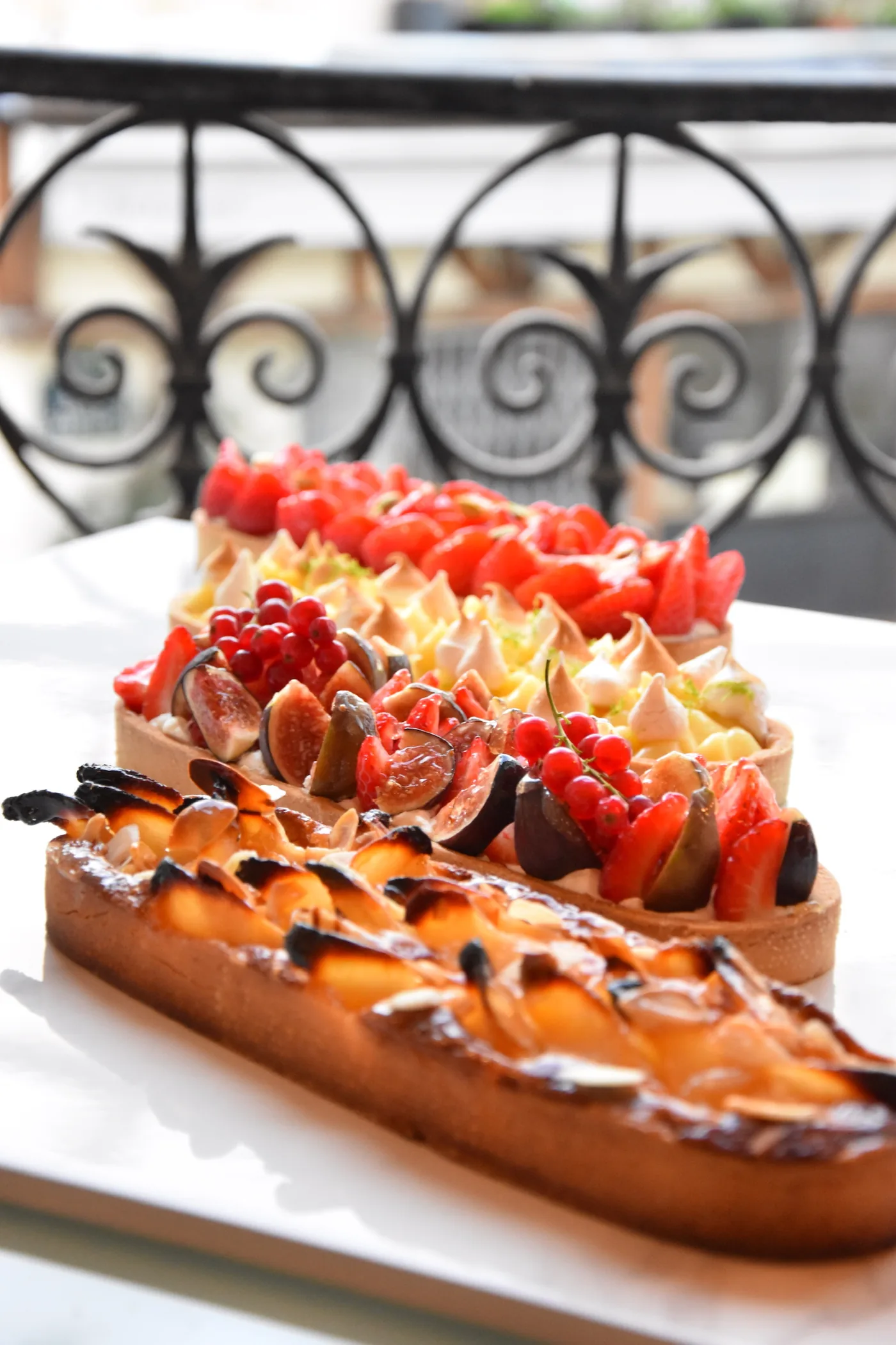 Une tarte aux fraises et au chocolat, ferronnerie parisienne en fond